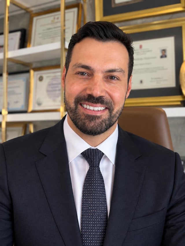 Op. Dr. M. Hakan Bulam at his clinic, in front of his specialist certificates