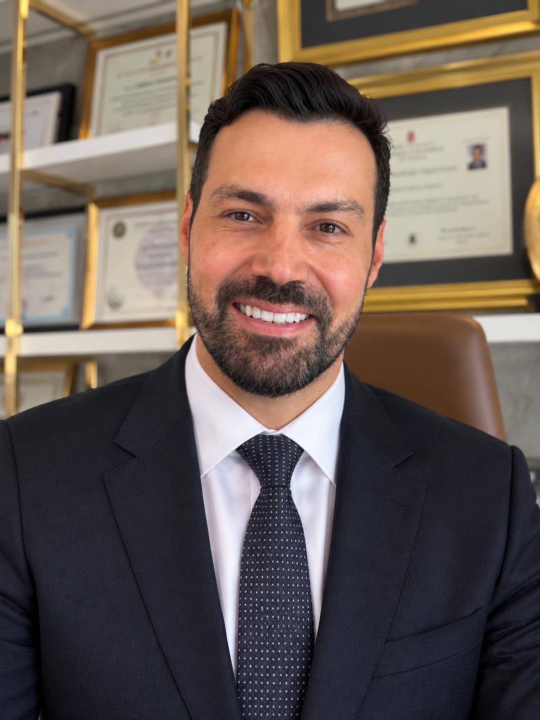Op. Dr. M. Hakan Bulam at his clinic, in front of his specialist certificates